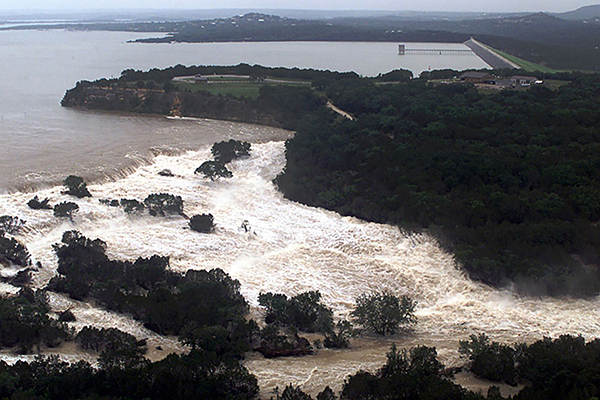 photo of water overtopping a dam in texas