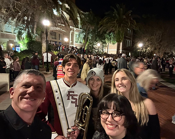 photo of famu-fsu engineering alumnus jeremy graeber outside with marching chiefs student and family at night
