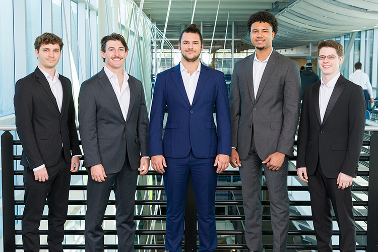 photo of five men in suits standing by a railing