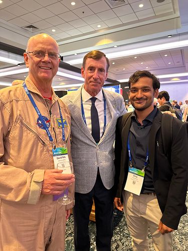 three men smiling with arms around shoulders