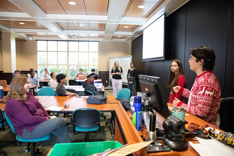 photo of students giving presentation in full classroom