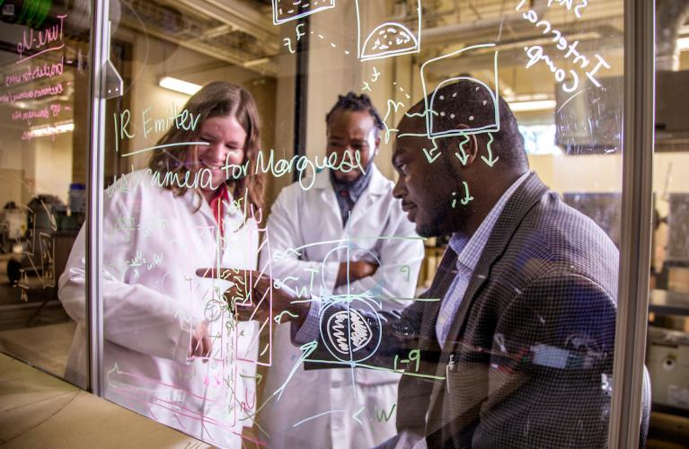 Tarik Dickens, Ph.D. teaches two graduate students in the DeXter 3D printing and additive manufacturing lab.