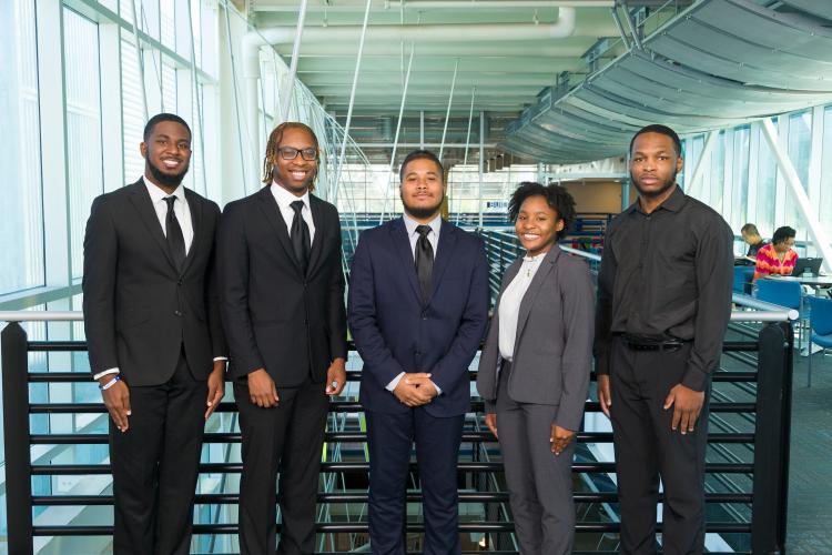The five members of engineering senior design team 207 stand together on the third floor breezeway at the FAMU-FSU College of Engineering.
