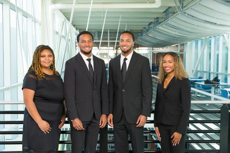 The four members of engineering senior design team 213 stand together on the third floor breezeway at the FAMU-FSU College of Engineering.