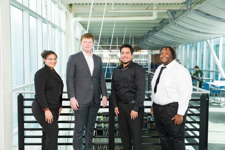 The four members of engineering senior design team 219 stand together on the third floor breezeway at the FAMU-FSU College of Engineering.