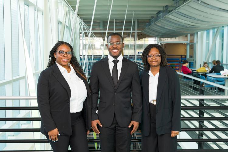 The three members of engineering senior design team 225 stand together on the third floor breezeway at the FAMU-FSU College of Engineering.