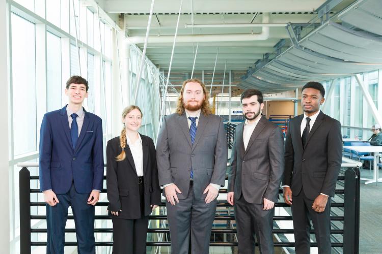 The five members of engineering senior design team 304 stand together on the third floor breezeway at the FAMU-FSU College of Engineering.