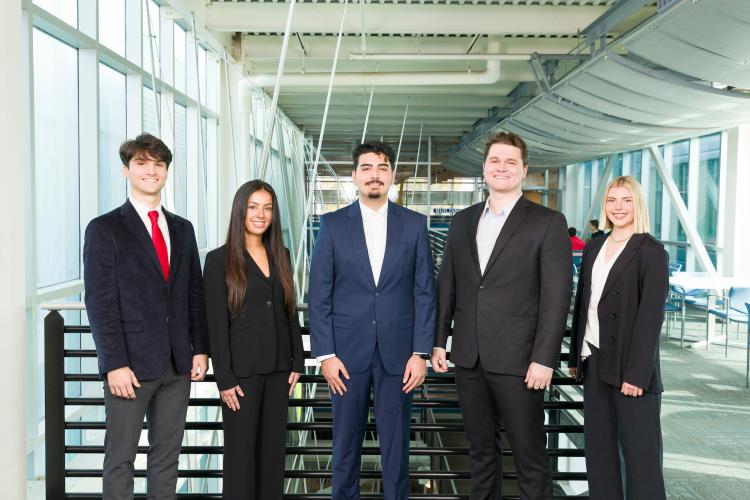 The five members of engineering senior design team 407 stand together on the third floor breezeway at the FAMU-FSU College of Engineering.