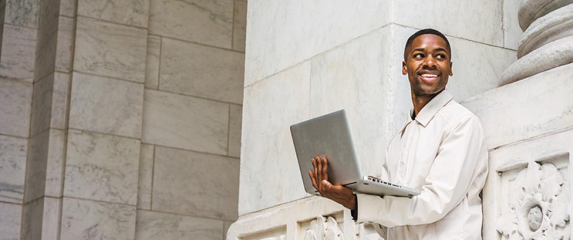 college student in white jacket with laptop