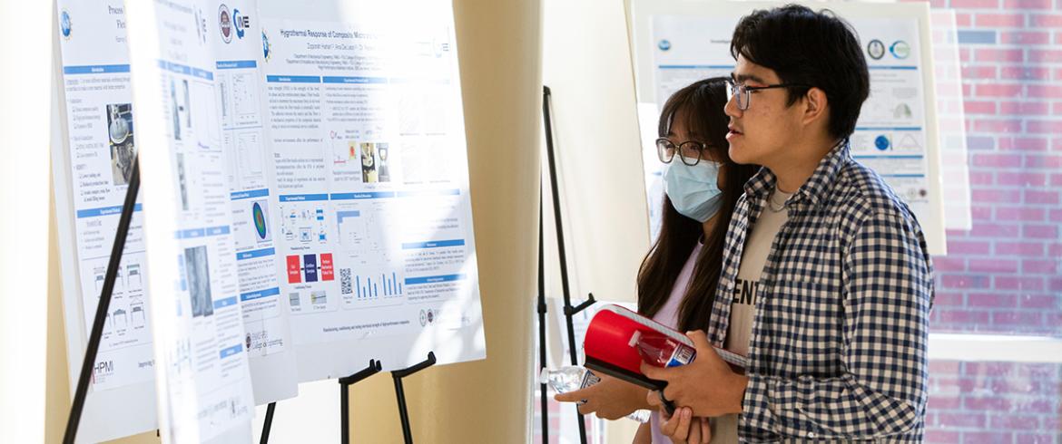 photo of two engineering students looking at research posters on easels