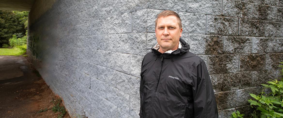 photo of civil engineering professor scott wasman in front of a bridge constructed with GRS technology