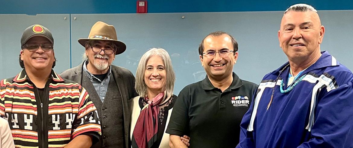 photo of five people standing in a line facing the camera