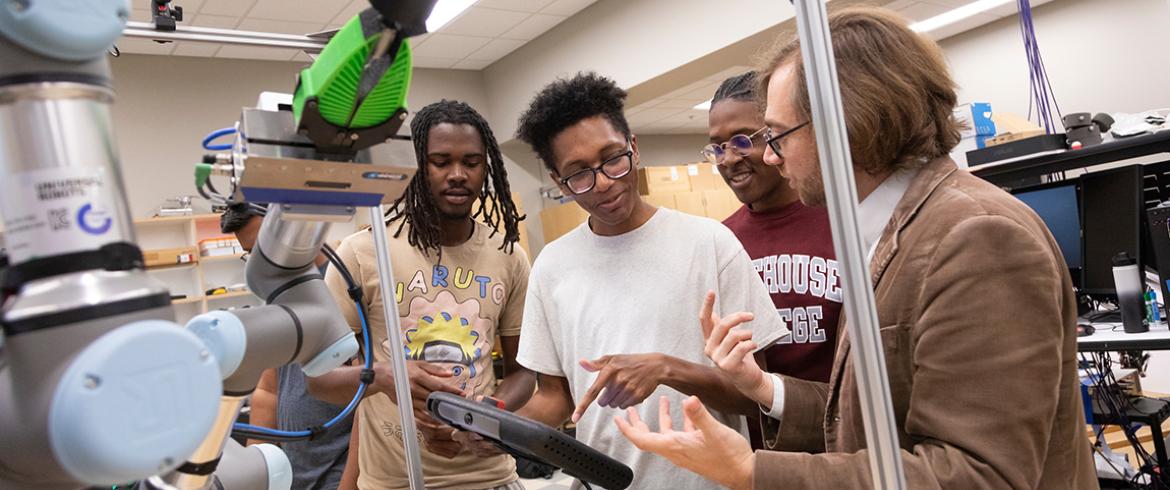 photo of professor and students with robotic arm in lab at famu-fsu engineering
