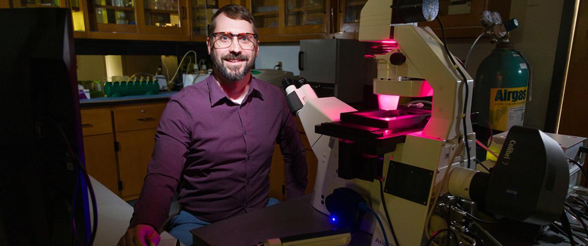photograph of famu-fsu engineering professor tristan driscoll at a microscope in his lab