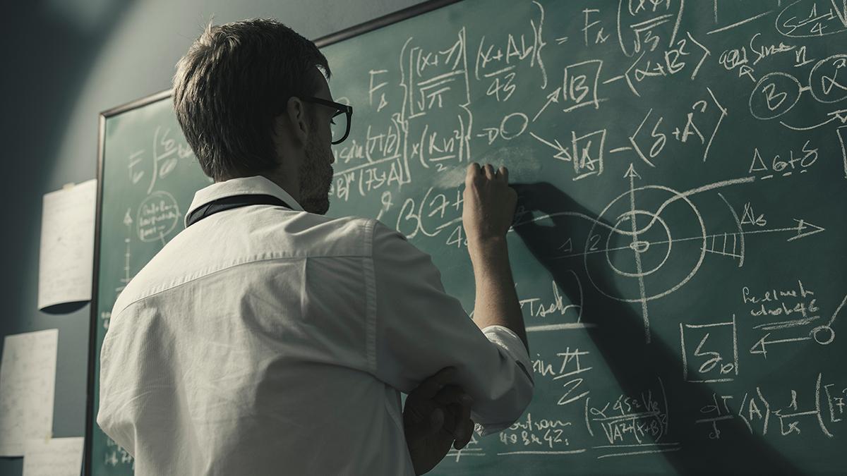 professor doing math on a chalkboard
