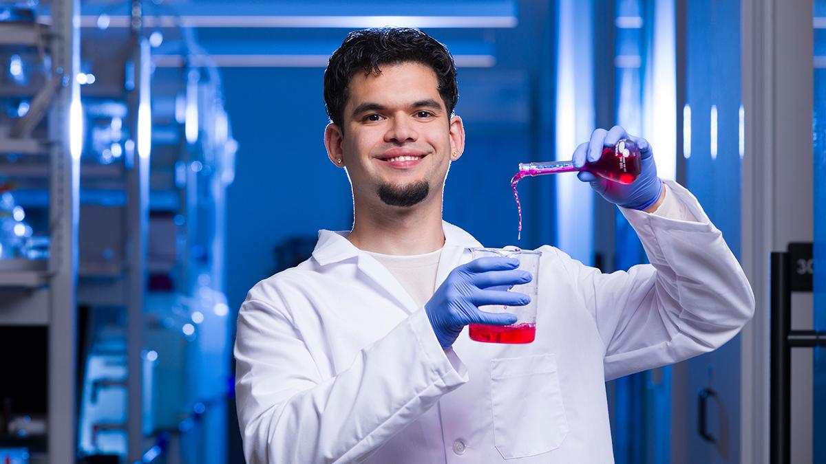 photo of engineering student pouring chemical into beaker