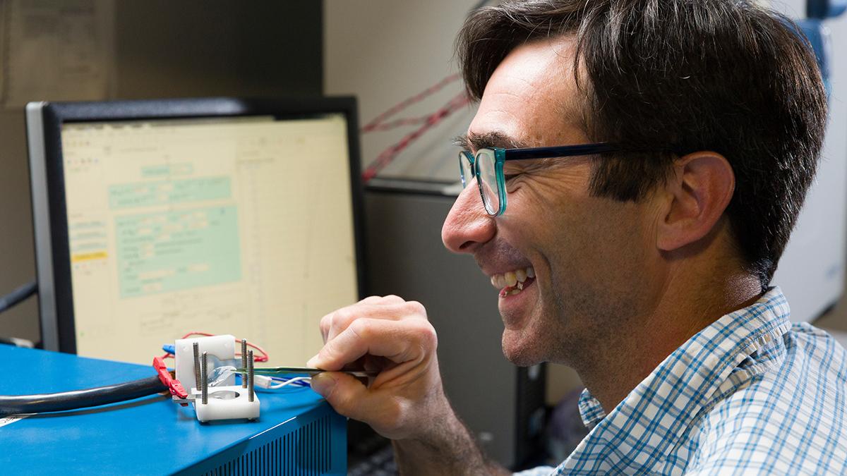 photo of famu-fsu engineering professor daniel hallinan working in lab and smiling