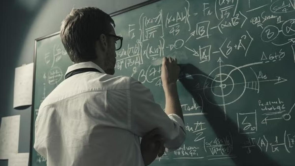 professor doing math on chalkboard