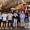 photo of group of students in front of antique silver airplanes