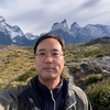photo of many with glasses in jacket standing in front of chilean mountains and water